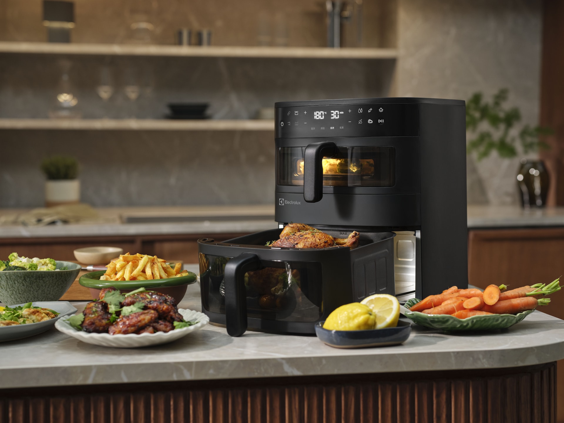 Electrolux karšto oro gruzdintuvė su kepta vištiena ir garnyrais ant virtuvės stalviršio.